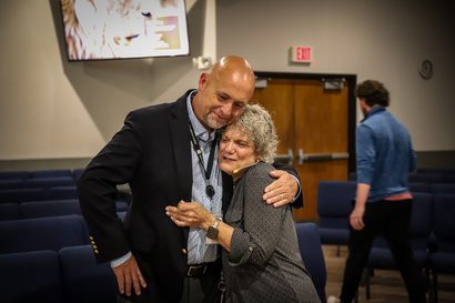 Ms. Sis embracing a colleague