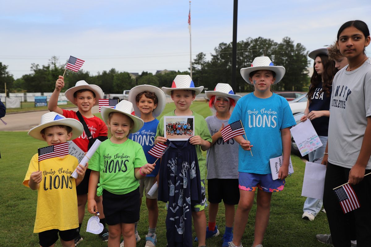 Elementary students holding small American flags