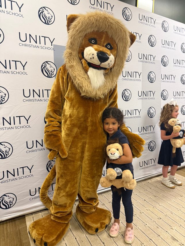 A student with the Unity lion mascot at Build a Lion Night