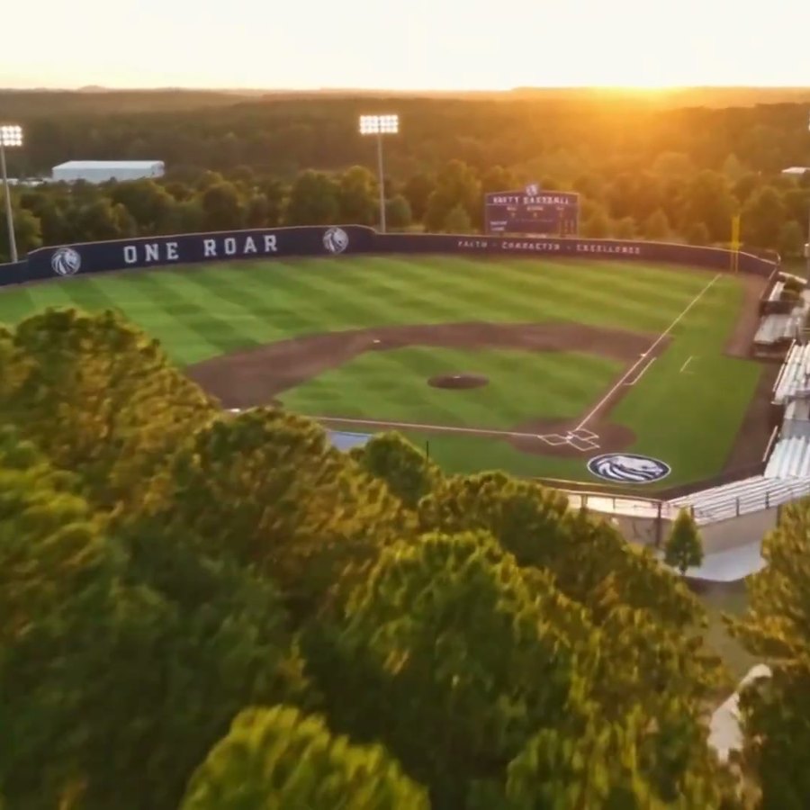 A rendering of a baseball field at sunset, the outfield wall reading One Roar